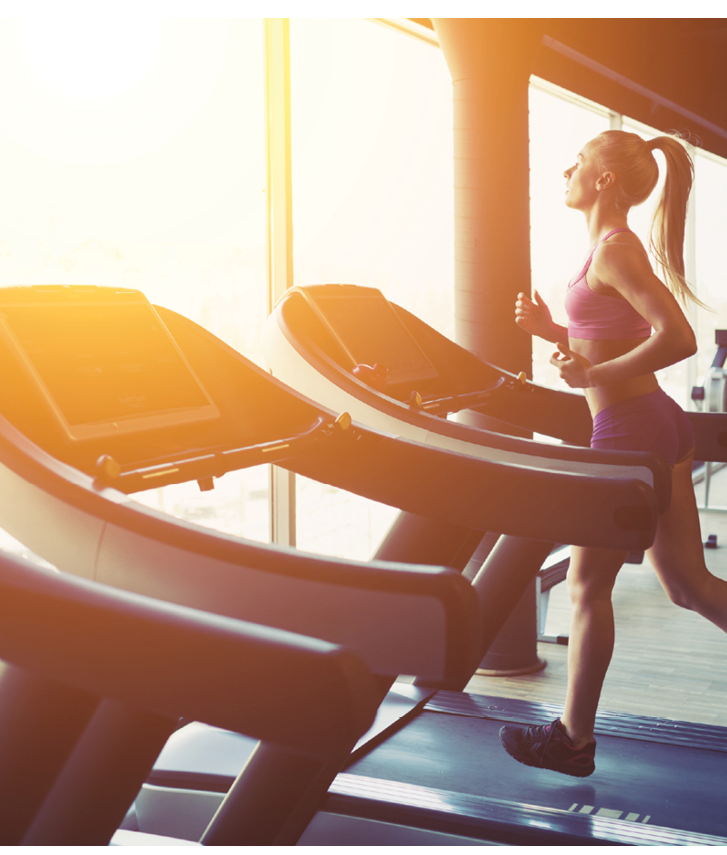 Fitness girl running on treadmill  Woman with muscular legs in gym